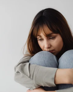 Femme pensive face aux choix et aux préoccupations liés à l’argent.